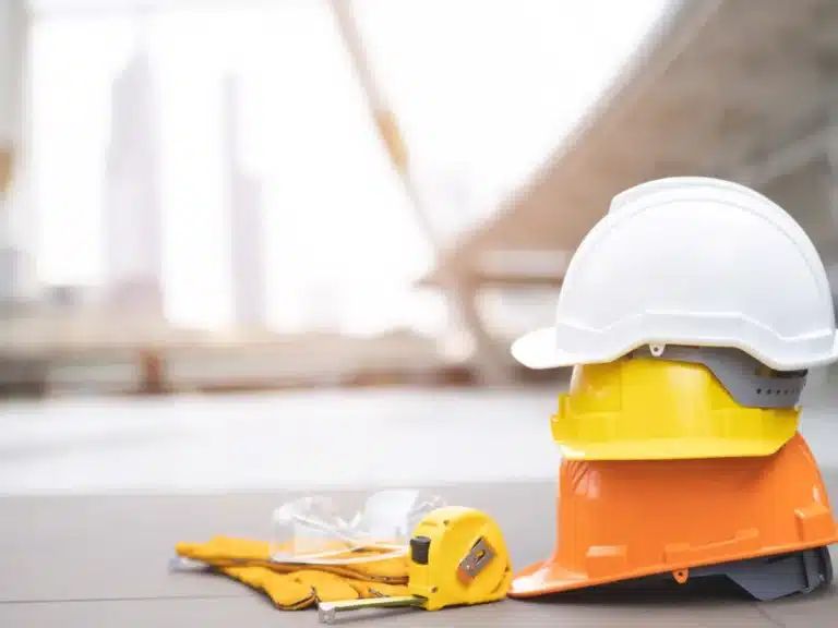 Yellow and white safety helmets resting on a concrete floor at a construction site